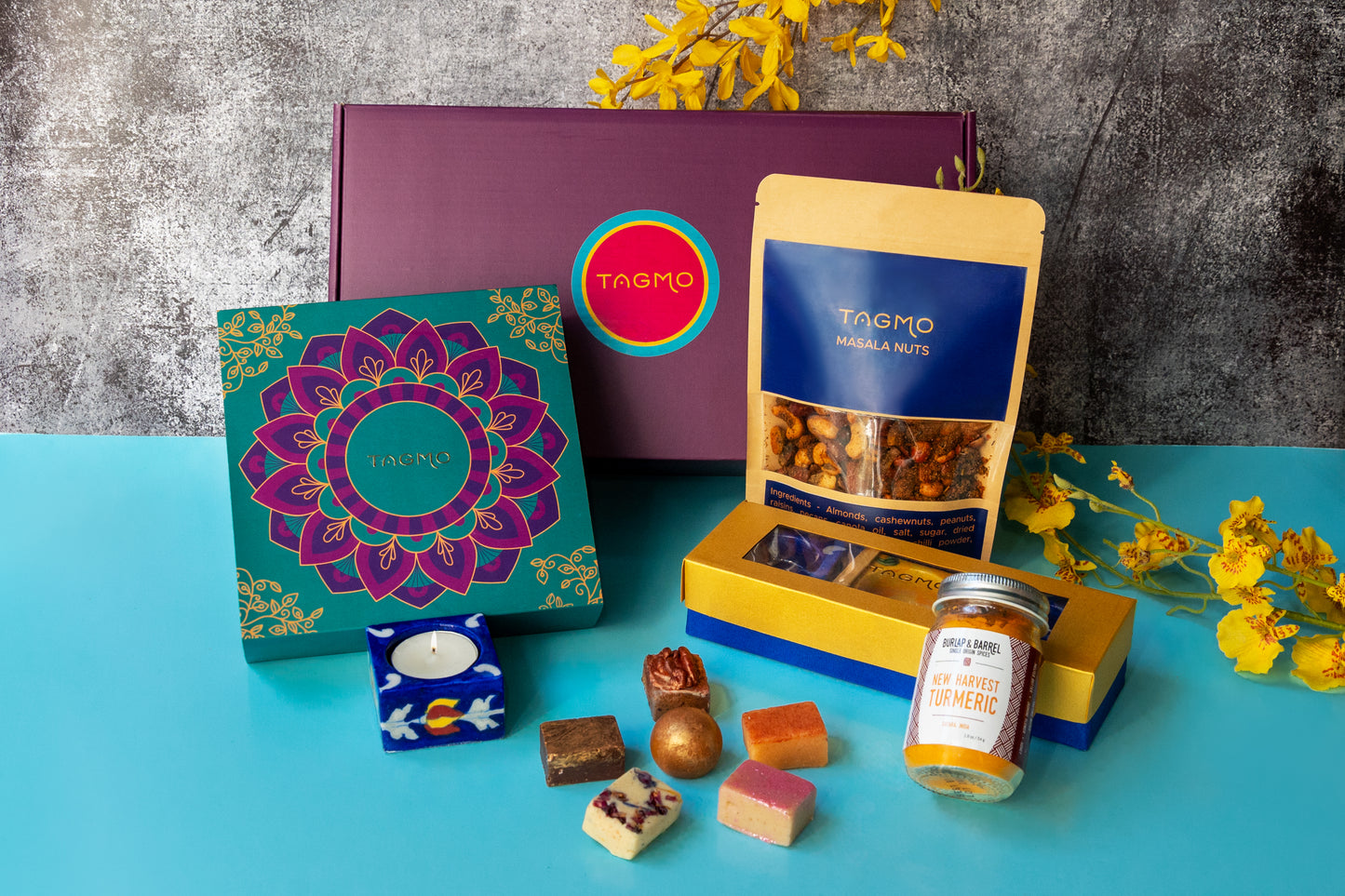 Devi Collection Shopify product: Assortment of traditional Indian sweets, snacks, and décor items including katli, ladoos, diyas, masala nuts, and more, showcased in an elegant gift box design.