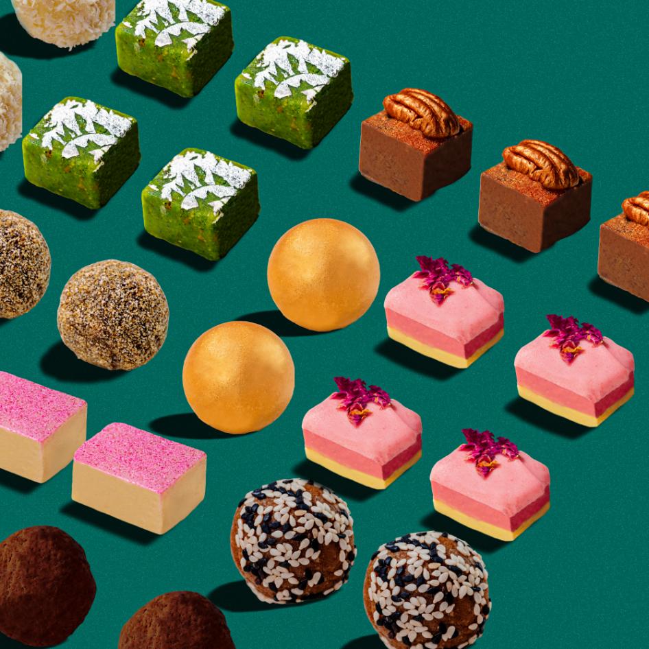 
                      
                        Colorful assortment of Indian sweets for Diwali, including green pistachio burfi, golden kaju katli, pink rose coconut burfi, and chocolate ladoos, arranged on a teal background
                      
                    